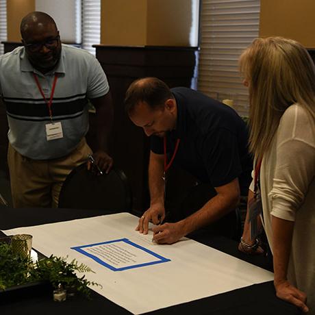 A man writes on a paper during an event